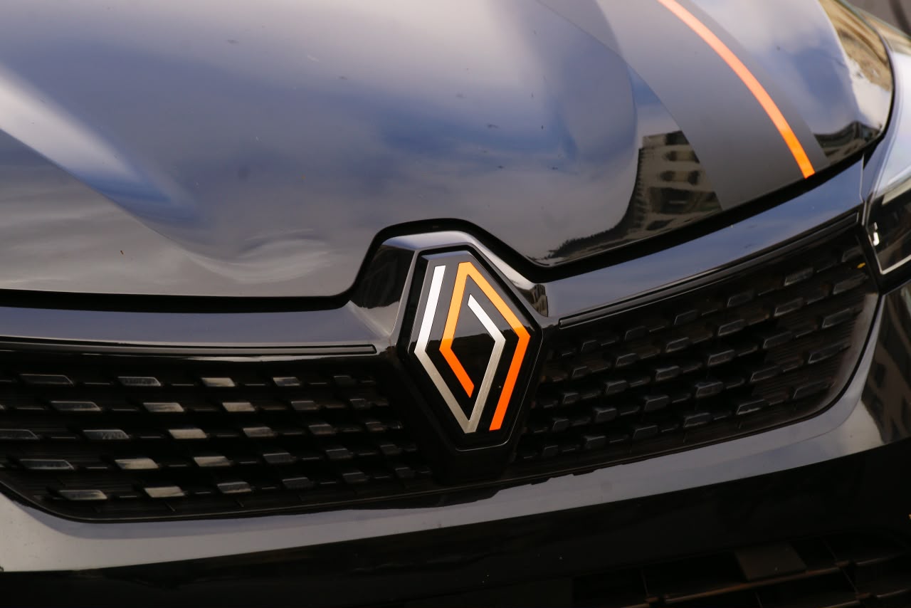 Close-up of the Renault badge and orange stripe on a black car from the Carhub fleet